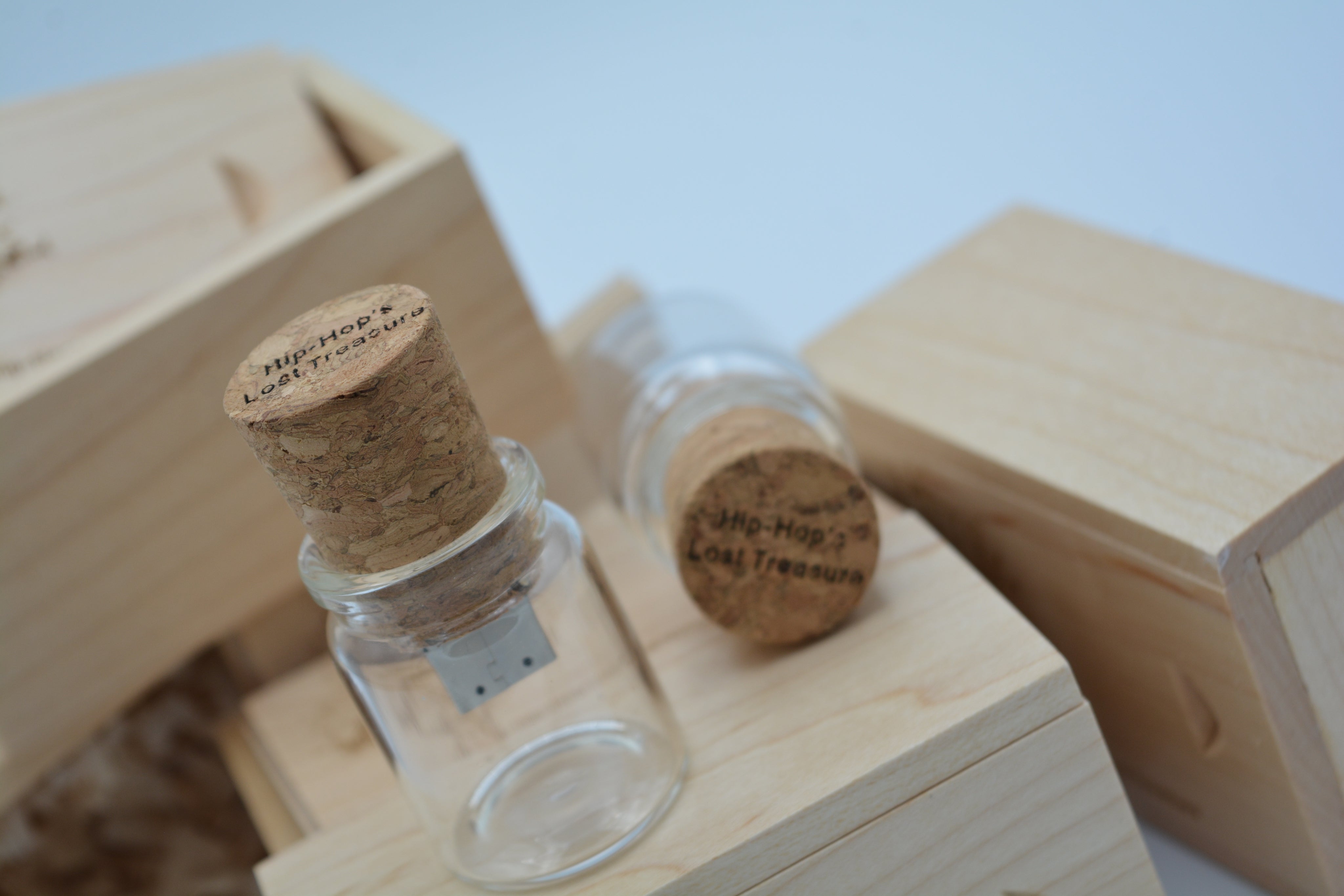 Two glass bottles with cork lids on a wooden surface